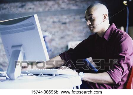 Side profile of a young man using a computer View Large Photo Image Stock Image - Side profile of a young man using a computer. Fotosearch