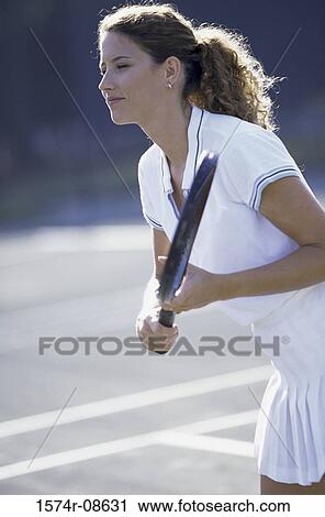 Side profile of a young woman playing tennis View Large Photo Image Stock Image - Side profile of a young woman playing tennis. Fotosearch