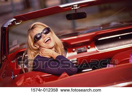 Stock Photo - Side profile of a young woman sitting in a car. Fotosearch