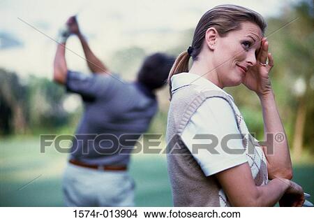 Picture - Side profile of a young woman standing on a golf course. Fotosearch