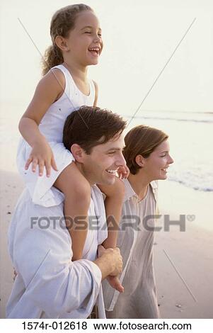 Stock Photo - Side profile of daughter riding on her father's shoulders. Fotosearch