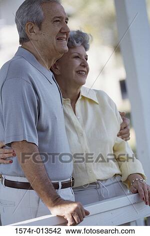 Side profile of senior couple standing with their arms around View Large Photo Image Stock Image - Side profile of senior couple standing with their arms around. Fotosearch