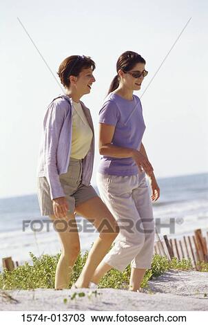 Side profile of two mid adult women walking on the beach View Large Photo Image Stock Image - Side profile of two mid adult women walking on the beach. Fotosearch