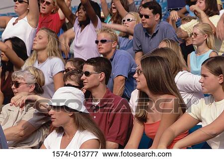 Stock Photo - Spectators sitting in a stadium. Fotosearch