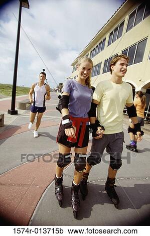 Teenage boy and a teenage girl inline skating on the sidewalk View Large Photo Image Stock Image - Teenage boy and a teenage girl inline skating on the sidewalk. Fotosearch