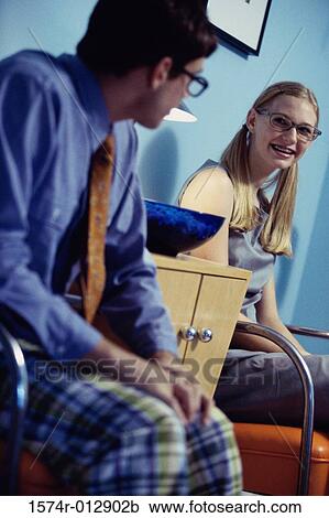 Stock Image - Teenage boy and a teenage girl looking at each other. Fotosearch