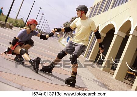Teenage couple skating in front of a building View Large Photo Image Stock Image - Teenage couple skating in front of a building. Fotosearch