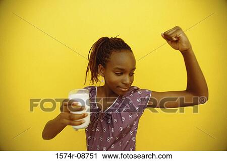 Teenage girl holding a glass of milk and flexing her muscles View Large Photo Image Stock Image - Teenage girl holding a glass of milk and flexing her muscles. Fotosearch