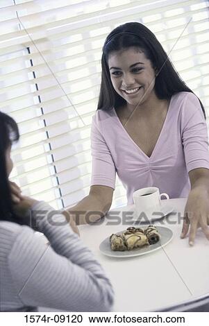 Teenage girl sitting at a table smiling View Large Photo Image Stock Image - Teenage girl sitting at a table smiling. Fotosearch