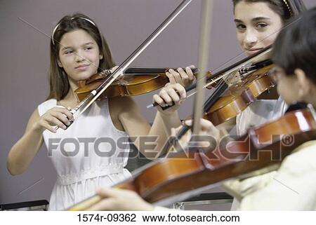 Three girls playing the violin View Large Photo Image Stock Image - Three girls playing the violin. Fotosearch