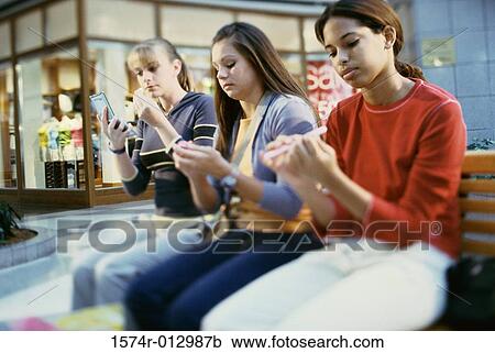 Stock Image - Three teenage girls grooming themselves. Fotosearch