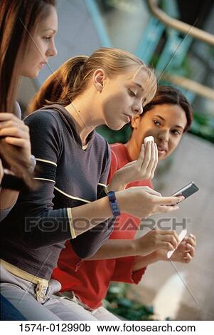 Stock Image - Three teenage girls grooming themselves. Fotosearch