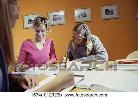 Stock Image - Three teenage girls studying in a room. Fotosearch