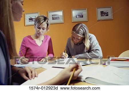 Stock Image - Three teenage girls studying in a room. Fotosearch
