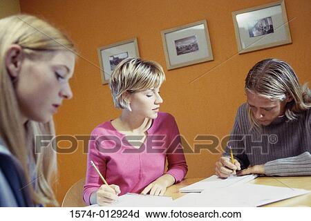 Stock Image - Three teenage girls studying in a room. Fotosearch