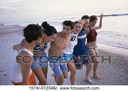 Stock Image - Three young couples running on the beach. Fotosearch