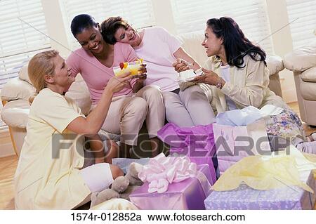 Stock Image - Three young women and a mature woman smiling. Fotosearch