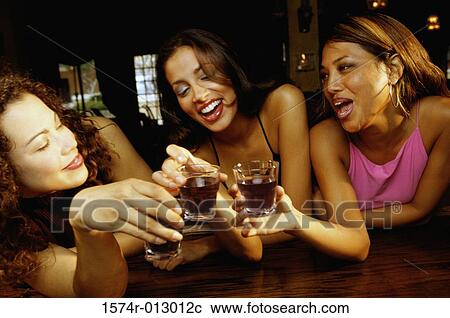 Three young women toasting with glasses in a bar View Large Photo Image Stock Image - Three young women toasting with glasses in a bar. Fotosearch
