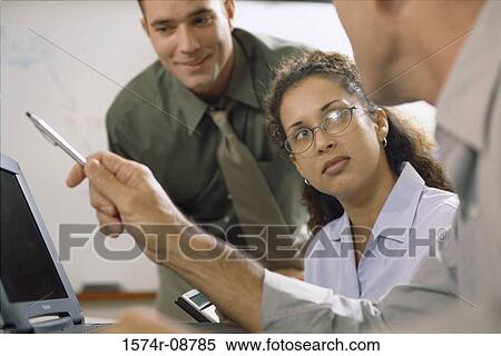 Two businessmen and a businesswoman working in front of a computer monitor View Large Photo Image Stock Photography - Two businessmen and a businesswoman working in front of a computer monitor. Fotosearch