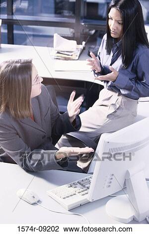 Two businesswomen discussing in an office View Large Photo Image Stock Image - Two businesswomen discussing in an office. Fotosearch