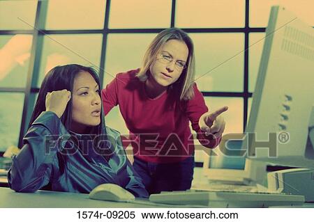 Stock Photography - Two businesswomen working on a computer. Fotosearch