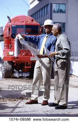 Two foremen looking at blueprints View Large Photo Image Stock Photograph - Two foremen looking at blueprints. Fotosearch