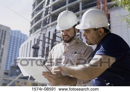 Stock Image - Two foremen working at a construction site. Fotosearch