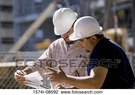 Two foremen working holding blue prints standing at a construction site View Large Photo Image Stock Image - Two foremen working holding blue prints standing at a construction site. Fotosearch