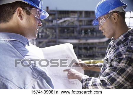 Stock Image - Two foremen working on blueprints. Fotosearch