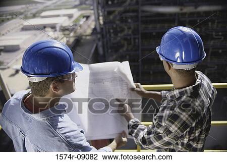 Two foremen working on blueprints View Large Photo Image Stock Image - Two foremen working on blueprints. Fotosearch