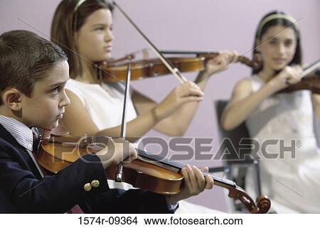 Two girls and a boy playing the violin View Large Photo Image Picture - Two girls and a boy playing the violin. Fotosearch