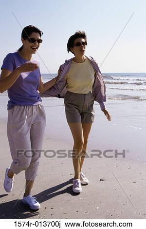 Two mid adult women walking on the beach View Large Photo Image Stock Image - Two mid adult women walking on the beach. Fotosearch