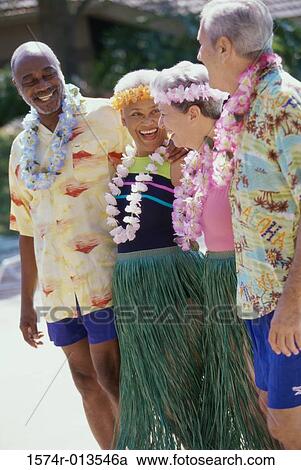 Stock Image - Two senior couples wearing Hawaiian outfits. Fotosearch