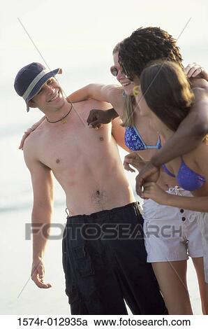 Stock Image - Two teenage couples standing together. Fotosearch