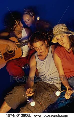 Two young couples on the beach at night View Large Photo Image Stock Image - Two young couples on the beach at night. Fotosearch