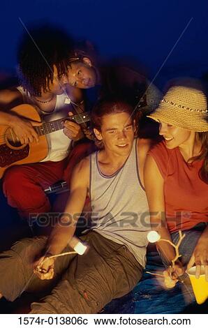 Two young couples on the beach at night View Large Photo Image Stock Image - Two young couples on the beach at night. Fotosearch