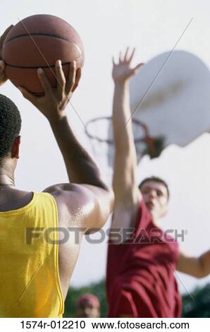 Stock Image - Two young men playing basketball. Fotosearch