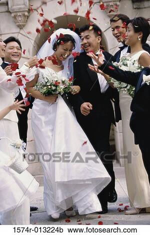 Wedding guests throwing rose petals on a newlywed couple View Large Photo Image Stock Image - Wedding guests throwing rose petals on a newlywed couple. Fotosearch