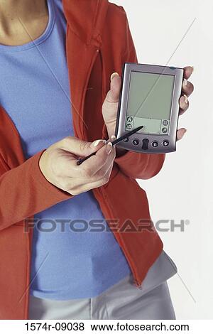 Stock Photo - Woman holding out a hand held device. Fotosearch