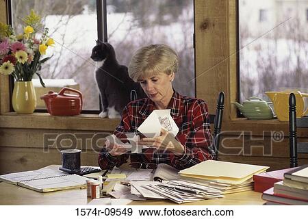 Woman reading bills View Large Photo Image Stock Photo - Woman reading bills. Fotosearch