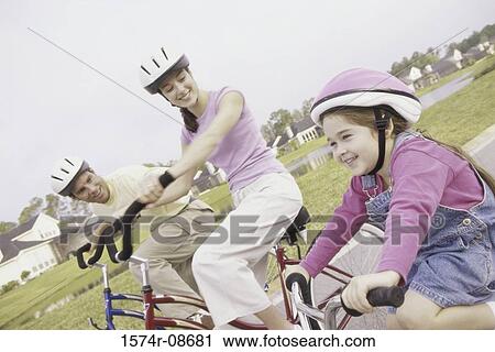 Young couple cycling with their daughter View Large Photo Image Stock Image - Young couple cycling with their daughter. Fotosearch