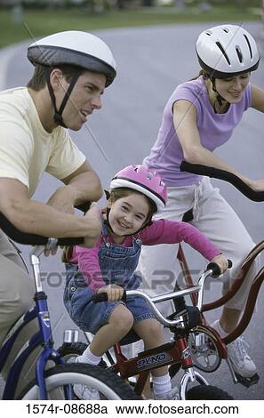 Young couple cycling with their daughter View Large Photo Image Stock Image - Young couple cycling with their daughter. Fotosearch