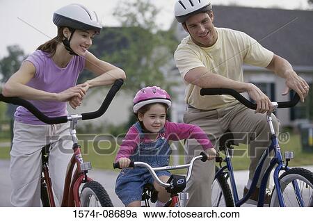 Young couple cycling with their daughter View Large Photo Image Stock Image - Young couple cycling with their daughter. Fotosearch
