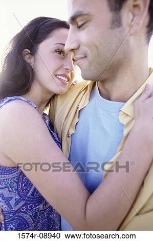 Young couple holding each other at the beach View Large Photo Image Stock Image - Young couple holding each other at the beach. Fotosearch