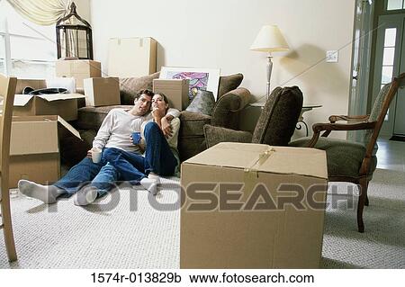 Young couple holding two cups of coffee sitting on the floor View Large Photo Image Stock Image - Young couple holding two cups of coffee sitting on the floor. Fotosearch