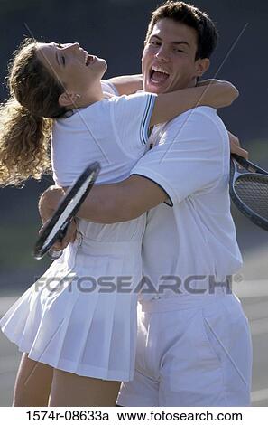 Young couple hugging each other at a tennis court View Large Photo Image Stock Image - Young couple hugging each other at a tennis court. Fotosearch