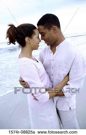Stock Image - Young couple hugging on the beach. Fotosearch
