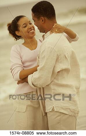 Stock Photography - Young couple hugging on the beach. Fotosearch