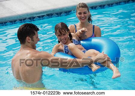 Young couple in a swimming pool with their daughter View Large Photo Image Stock Image - Young couple in a swimming pool with their daughter. Fotosearch