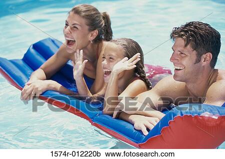 Young couple lying on a pool raft with their daughter View Large Photo Image Stock Image - Young couple lying on a pool raft with their daughter. Fotosearch